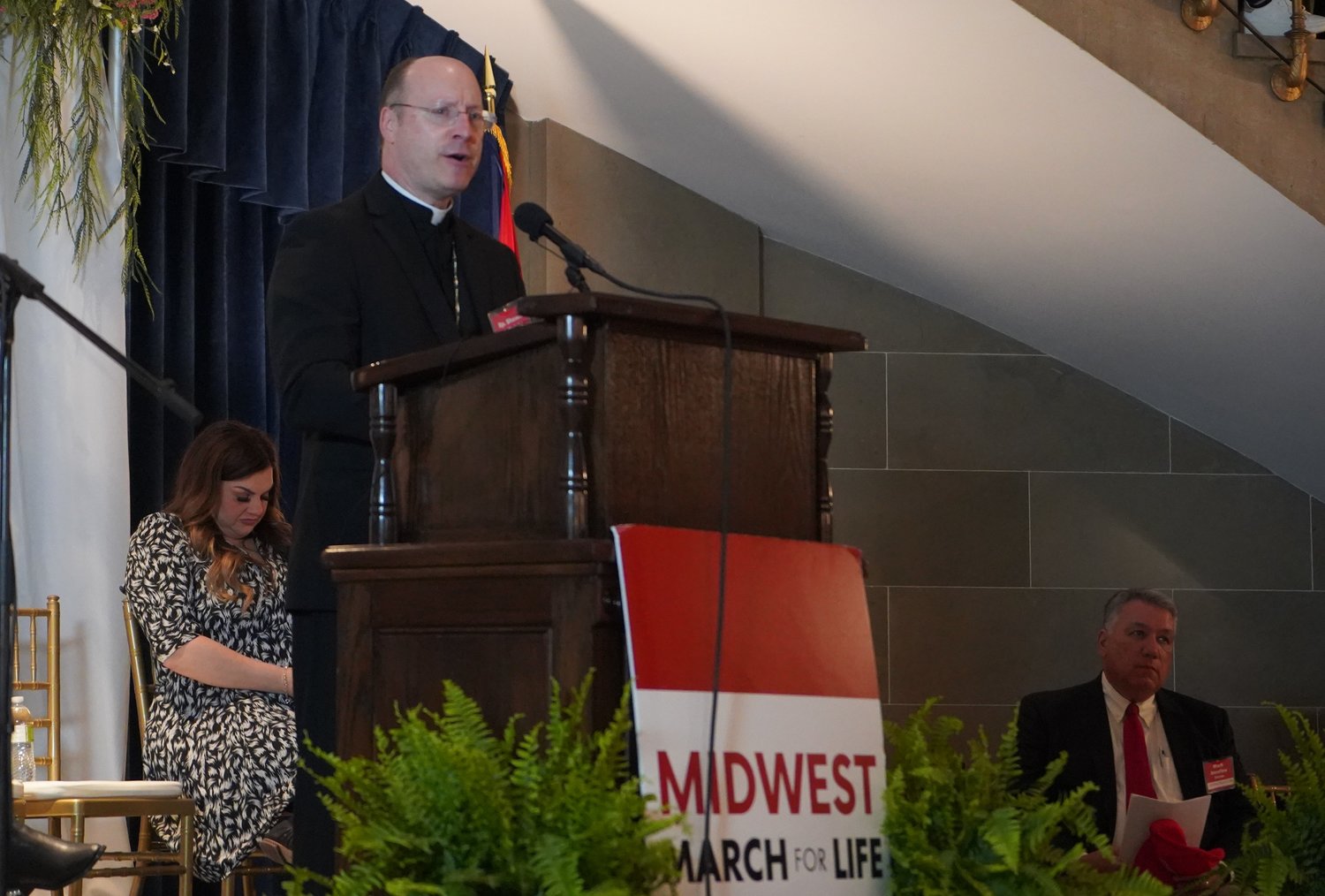 Bishop W. Shawn McKnight speaks to the crowd in the Rotunda of the Missouri State Capitol April 20 during a rally for the Midwest March for Life. Visible in the photo are keynote presenter Abby Johnson and Mark Serafino, master of ceremonies for the event. Mrs. Johnson is answering a woman who text-messaged her with searing regret over having recently had a late-term abortion.